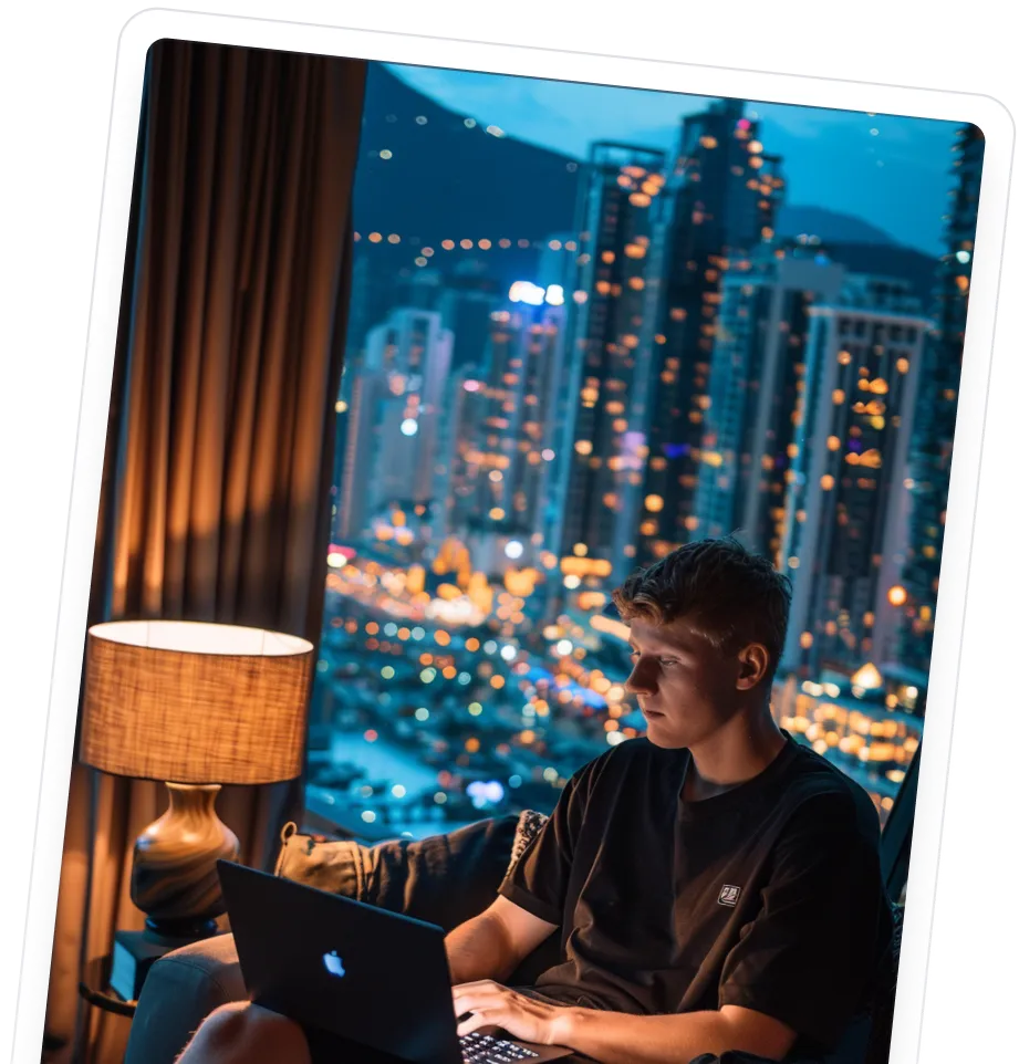A man sitting in a chair using a laptop computer.